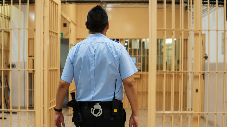 jailer walking through prison hall