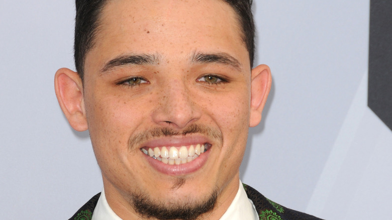 Anthony Ramos smiling in suit