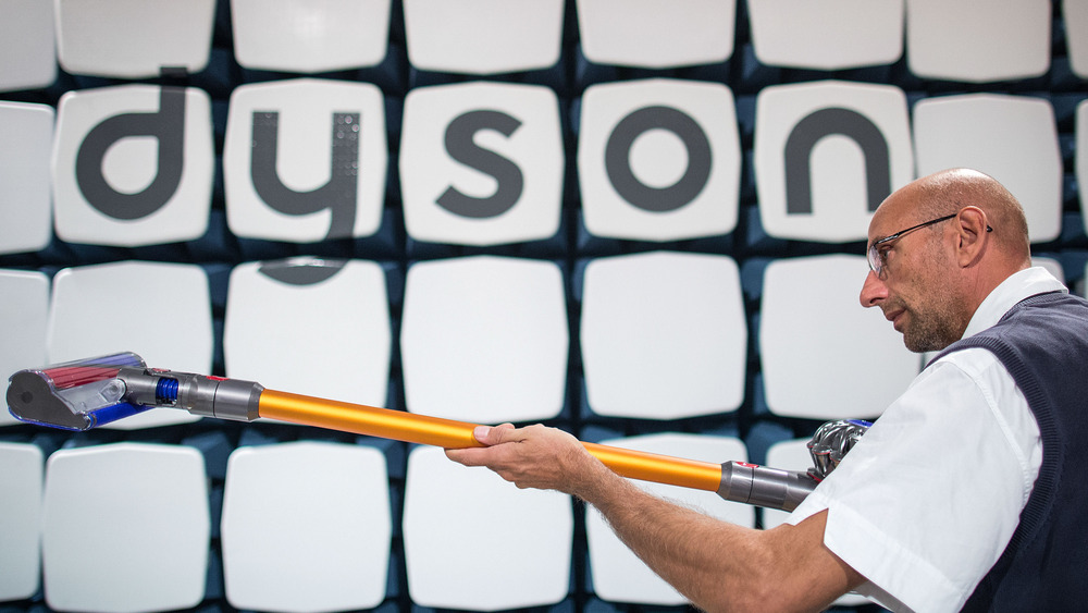 Man holding a Dyson vacuum