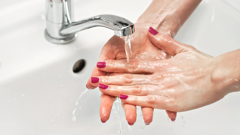 a woman rinsing her hands 