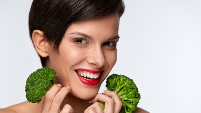 woman with broccoli and healthy skin
