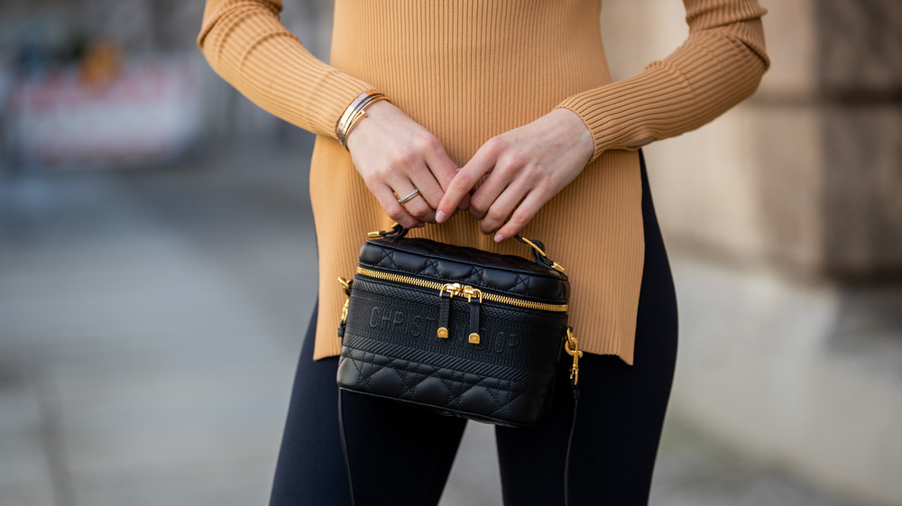 woman in leggings holding a purse
