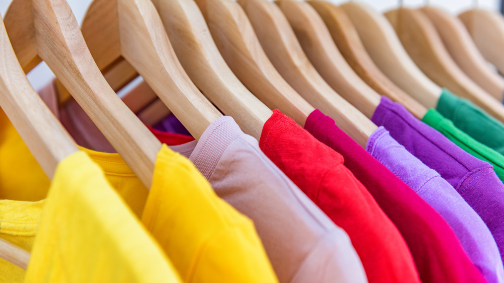 Colorful shirts hanging in a closet 