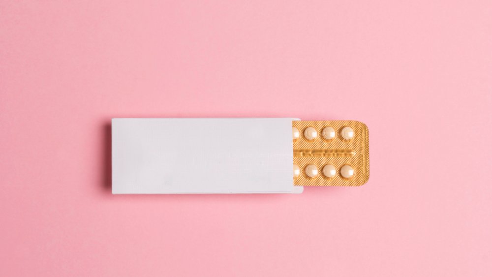 birth control pack against a pink background