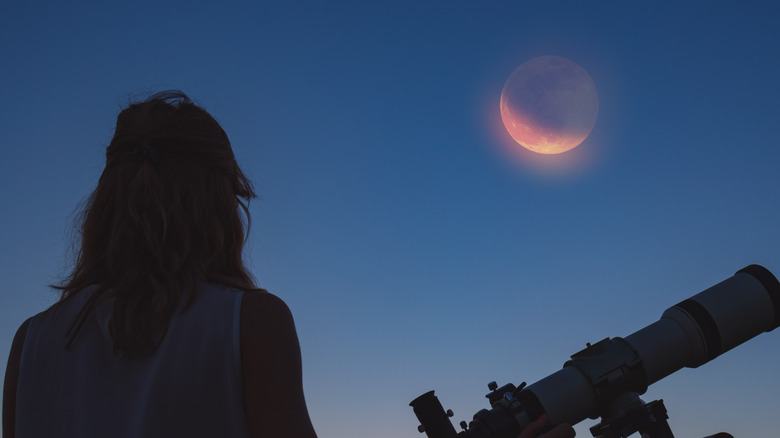Woman looking at lunar eclipse