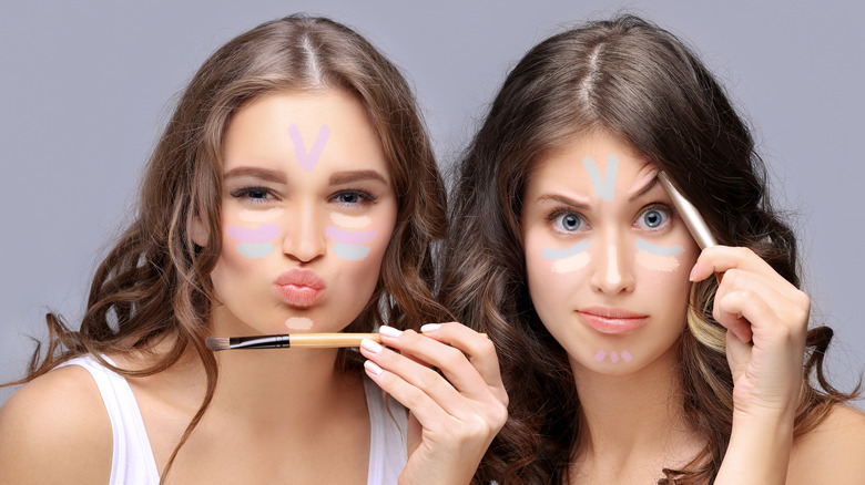 Two women applying makeup