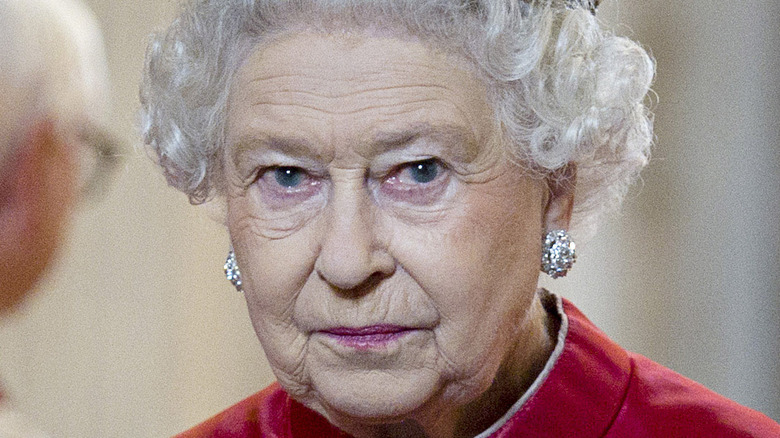 Queen Elizabeth staring into the camera wearing a crown