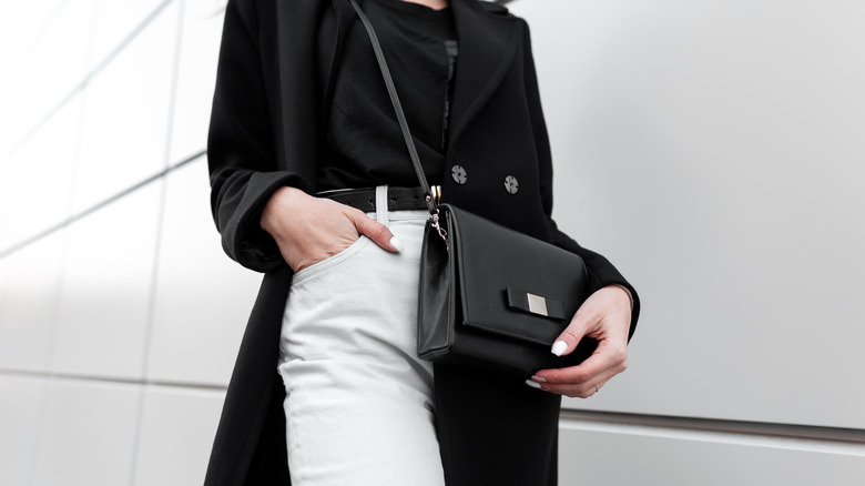 black purse paired with white jeans 