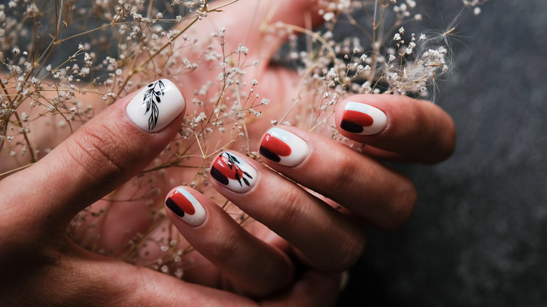 Hand with painted nails holding flowers