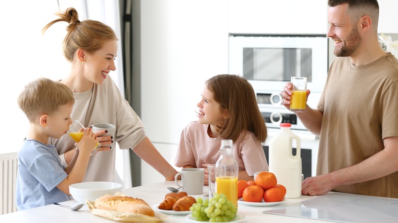 Family smiling around breakfast spread