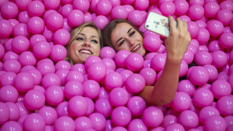 Women taking selfies in a ball-pit