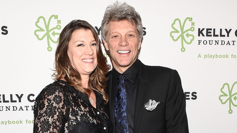 Jon Bon Jovi in black suit and Dorothea Hurley in black lace top 