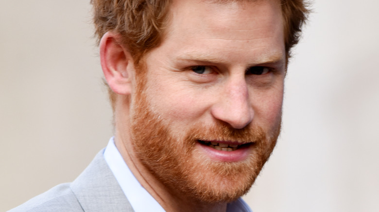 Prince Harry wears a gray suit.