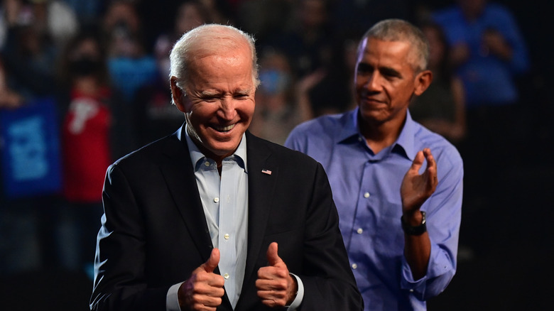 Joe Biden smiling and Barack Obama clapping