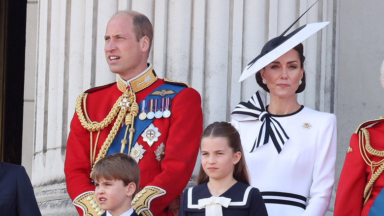 Prince William and Kate Middleton looking serious on balcony