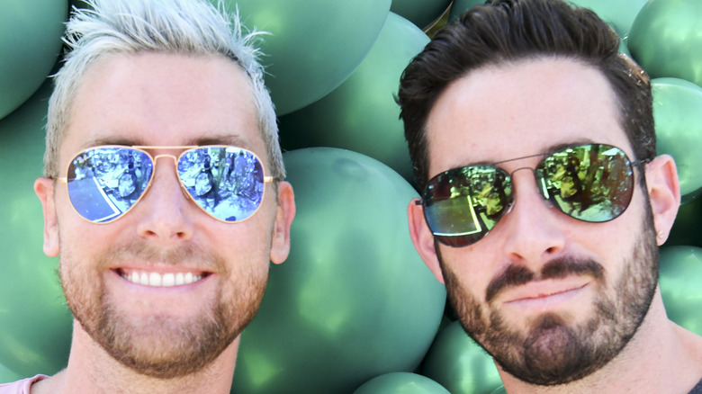 Lance Bass and Michael Turchin both wear sunglasses with balloon background