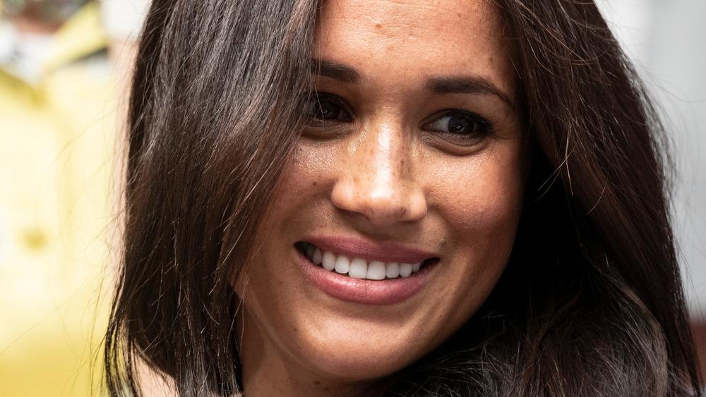 Meghan Markle wears her hair down and smiles