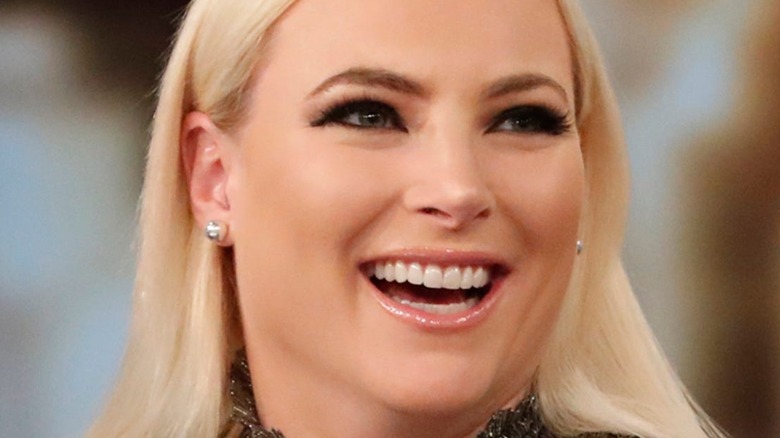 Meghan McCain looks to the side with an open-mouthed smile.