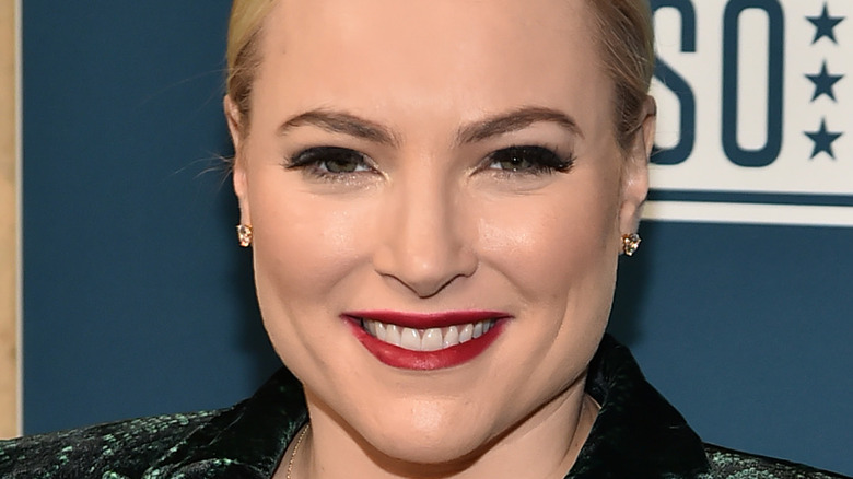 Meghan McCain wears red lipstick and smiles.