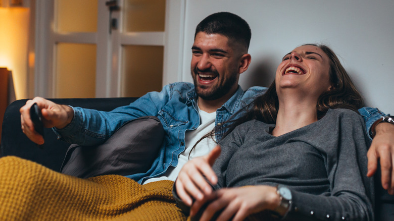 Couple laughing watching TV
