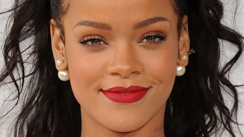 Rihanna, fashion icon, grinning at an event