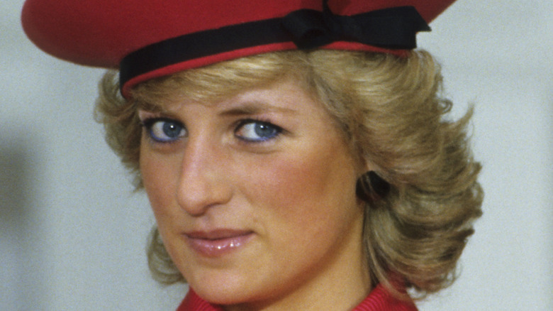 Princess Diana wearing blue eyeliner and smirking at camera