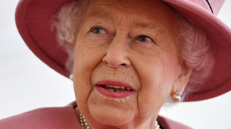 Queen Elizabeth wears a pink suit and hat
