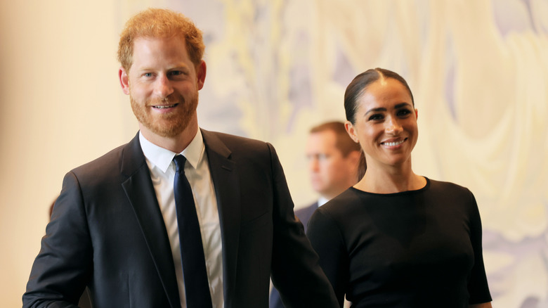 Prince Harry and Meghan Markle smile and walk together