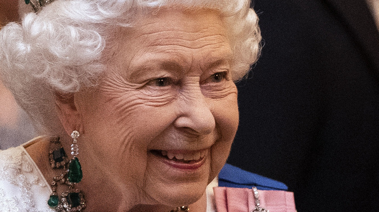 Queen Elizabeth smiling with emerald earrings