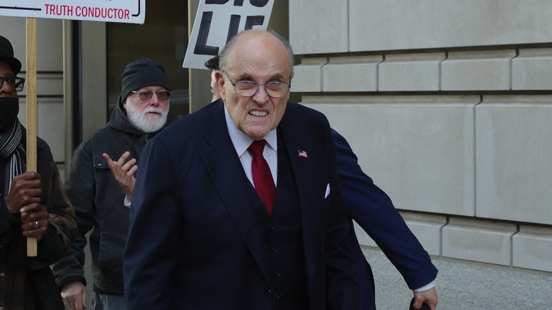 Rudy Giuliani being followed by protestors