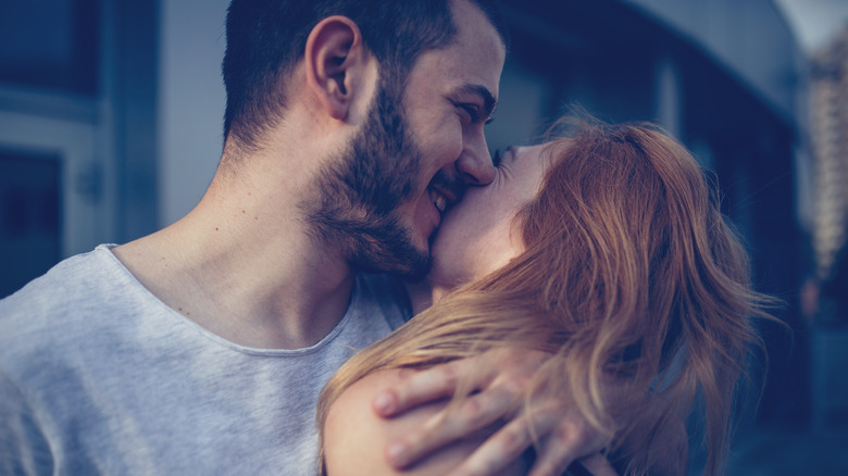Man with beard kisses woman