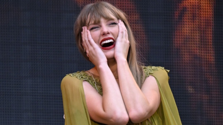Taylor Swift smiling, covering face with hands