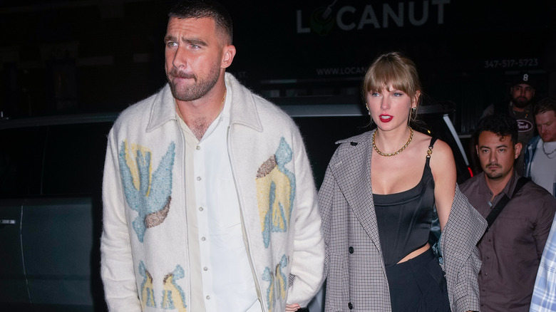 Travis Kelce and Taylor Swift walking into a restaurant