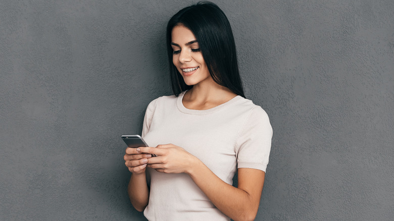 woman smiling and texting