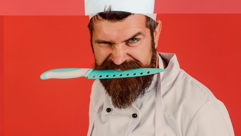Chef holding knife in teeth