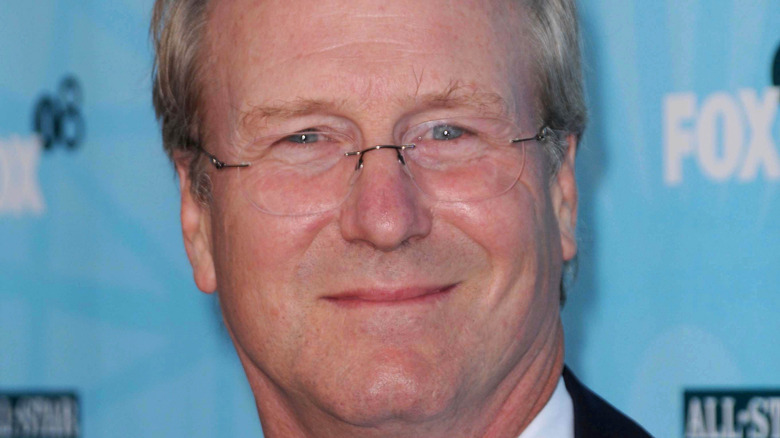 William Hurt poses with a smile.