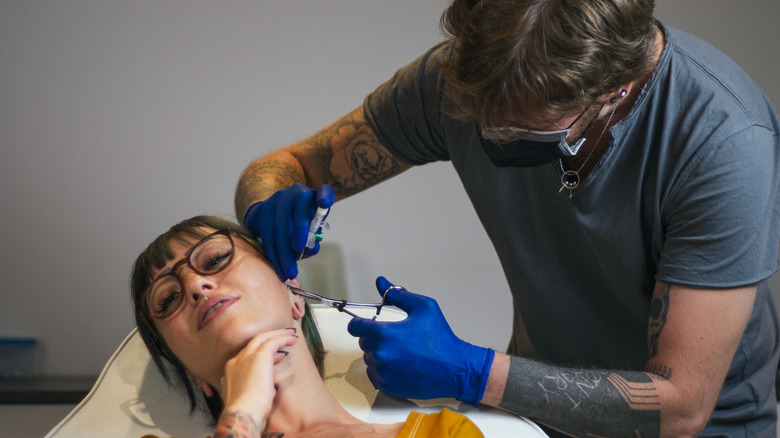 Woman getting a piercing
