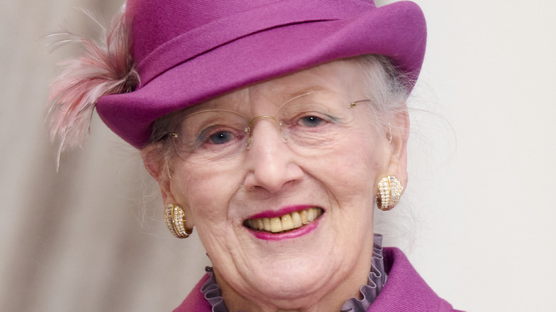 Queen Margrethe smiling in magenta hat