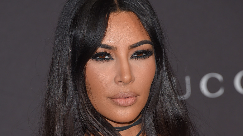 Kim Kardashian wears a black dress.