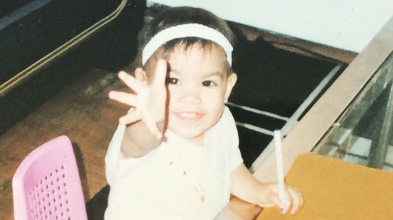 Alexandria Ocasio-Cortez as a little kid reaching out