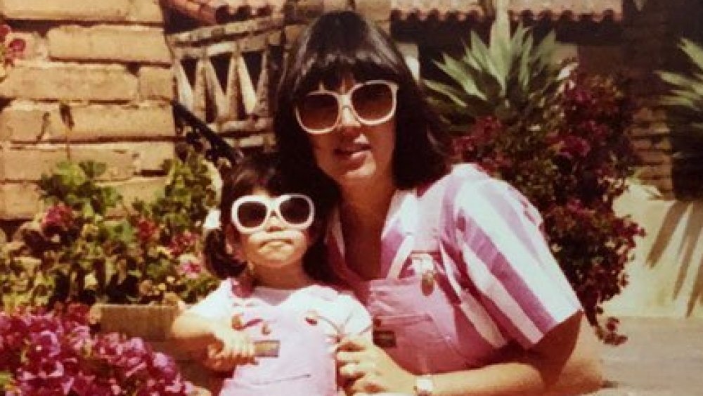 Kourtney Kardashian as a girl with her mother, wearing sunglasses