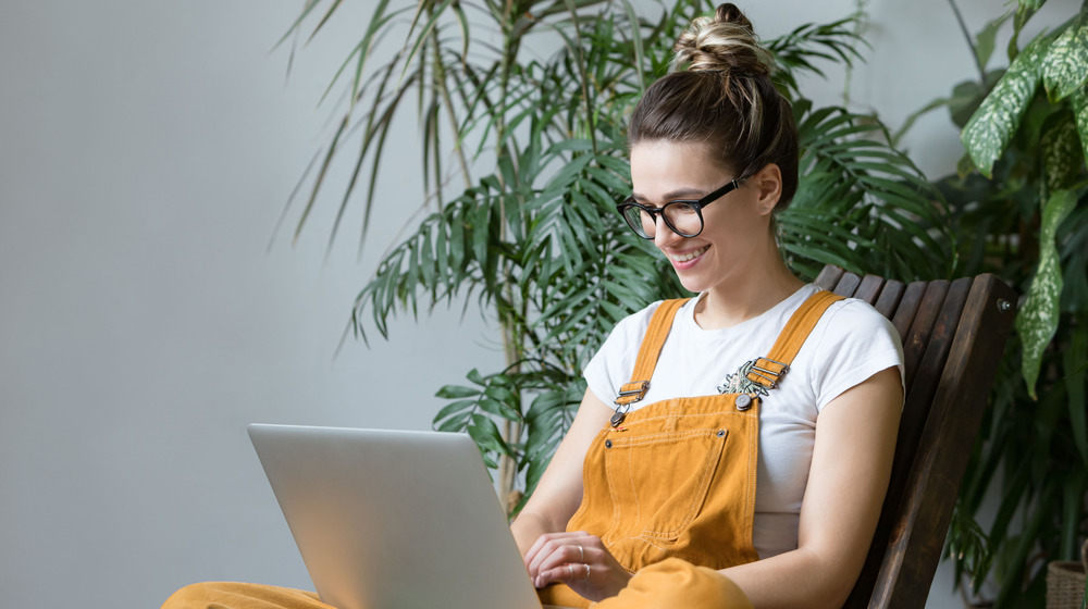 Woman on laptop with houseplants