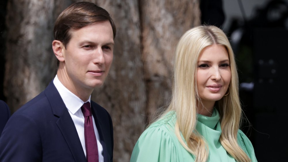 Jared Kushner and Ivanka Trump, walking outside with small smiles and looking off to the side