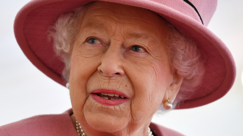 Queen Elizabeth in pink hat. 