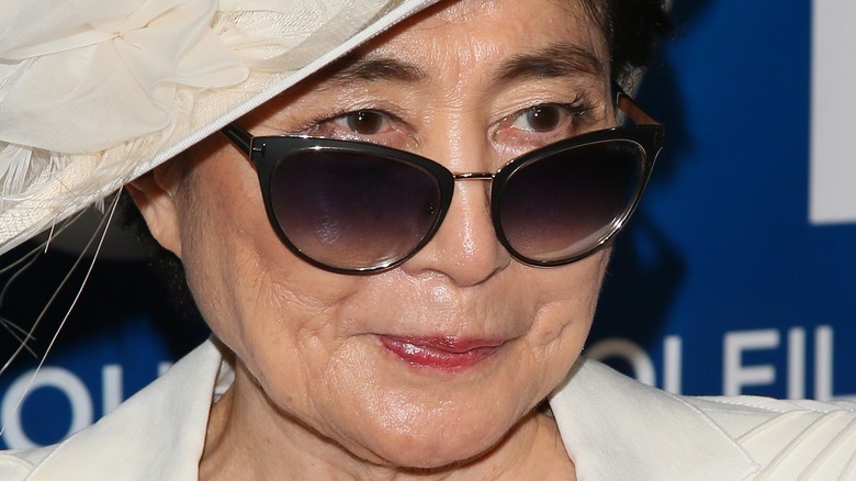 Yoko Ono wearing sunglasses and hat
