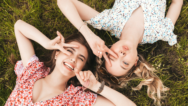 Two girls laying in grass