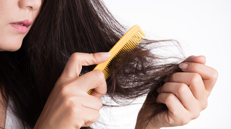 Woman brushing damaged hair
