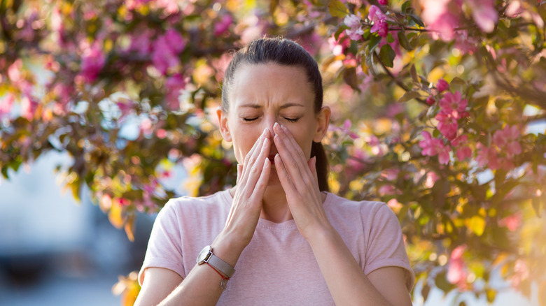 Woman outside sneezing