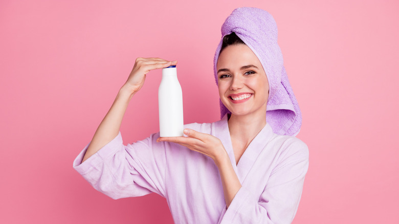 Woman holding shampoo bottle
