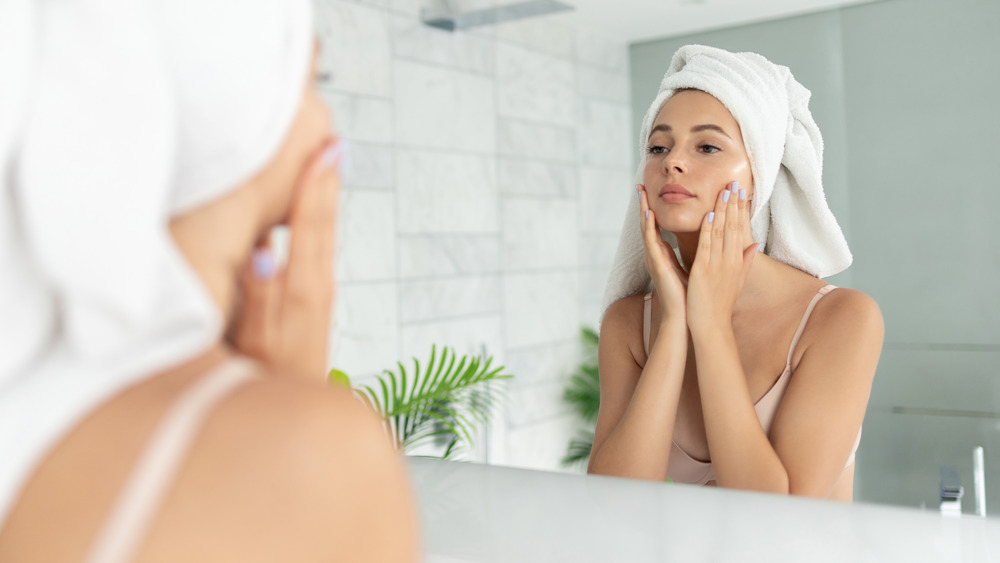 Woman applying skincare to face